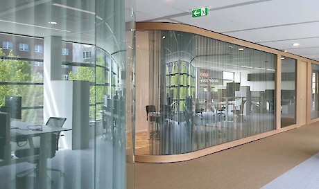 Meeting rooms and play room are behind the curved glass. Curtain from Kvadrat for privacy and acoustic